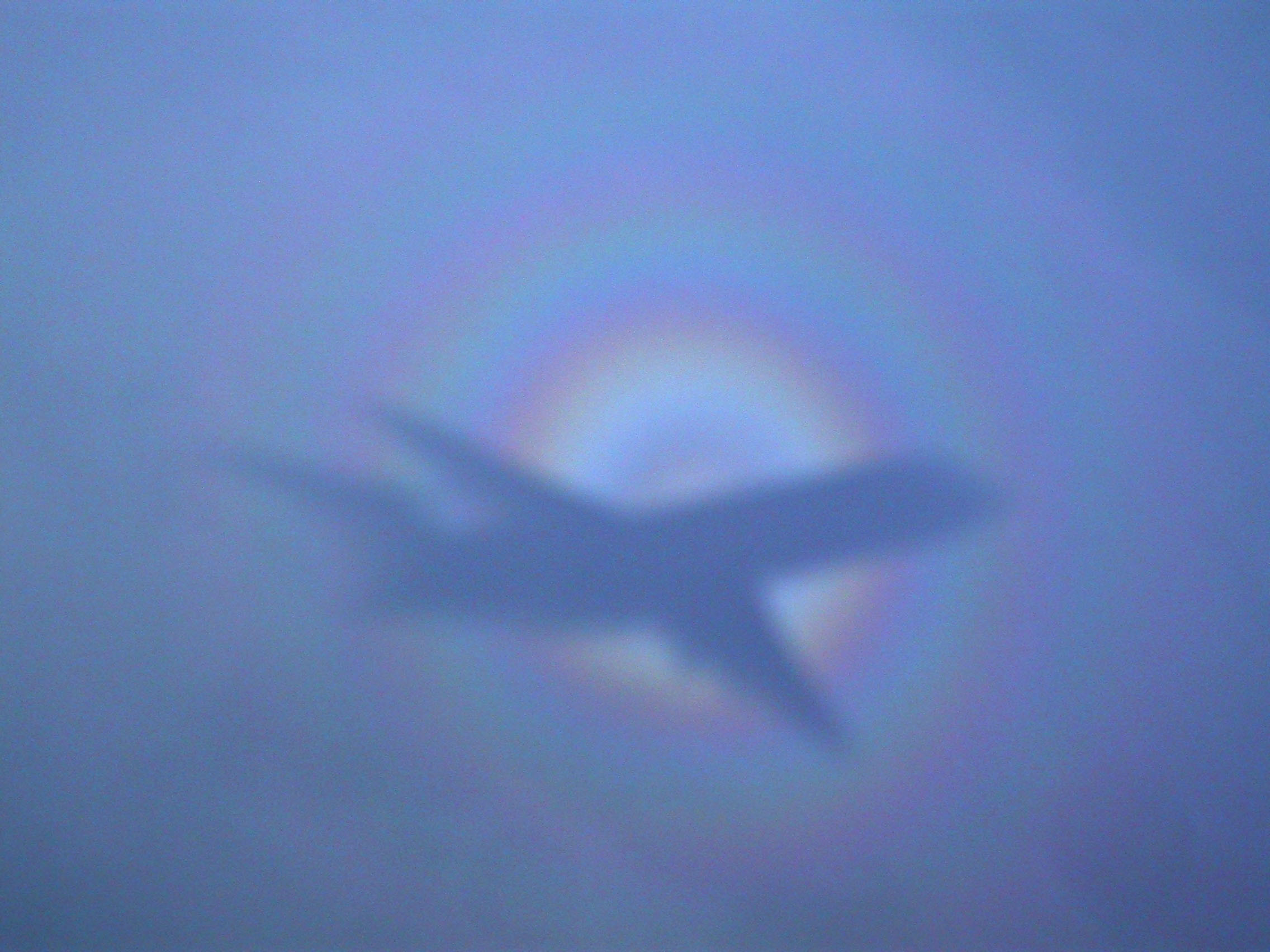2004 August 6

The Giant and the Glory
 * Credit & Copyright: Franz Kerschbaum (Univ. Vienna)

Explanation: 
On a flight from Vienna to Brussels, astronomer Franz Kerschbaum looked out the window and photographed this beautiful atmospheric phenomenon, the glory, shining in the direction directly opposite the Sun. Before airplanes, the glory, known to some as the heiligenschein or the Specter of the Brocken, was occasionally seen from mountaintops. There, when conditions were right, one could look away from the Sun and see what appeared to be the shadow of a giant surrounded by a bright halo. Of course, the giant turns out to be the observer, and in the modern version a silhouette of a plane frequently occupies the glory's center. The cause of the glory is relatively complex. Briefly, small droplets of water reflect, refract, and diffract sunlight backwards towards the Sun. The phenomenon has a counterpart in astronomy, where looking out from planet Earth in the direction opposite the Sun yields a bright spot called the gegenschein. 

Authors & editors: Robert Nemiroff (MTU) & Jerry Bonnell (USRA)
NASA Web Site Statements, Warnings, and Disclaimers
NASA Official: Jay Norris. Specific rights apply.
A service of: LHEA at NASA / GSFC
& Michigan Tech. U.